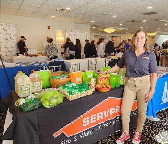 female standing by a table with SERVPRO marketing materials