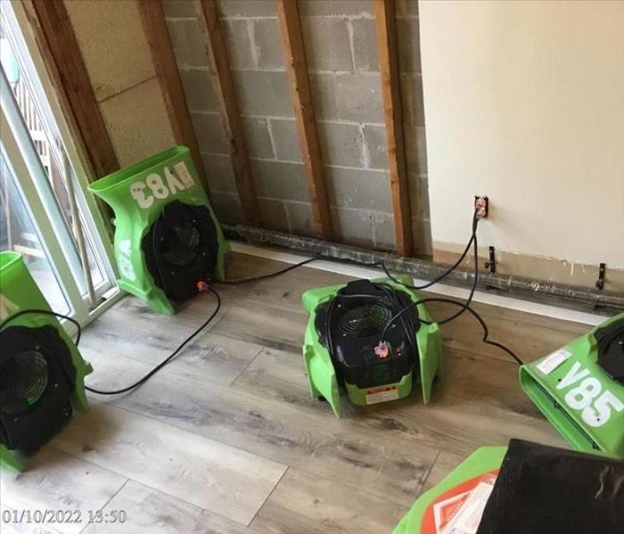 SERVPRO air movers drying a dining room wall with exposed studs and brickwork