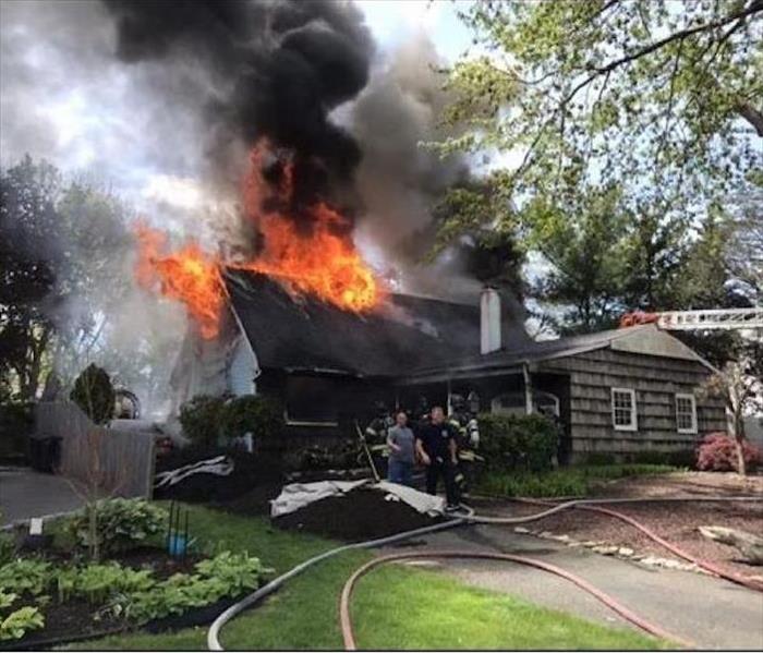 House with smoke and flames emitting from the roof